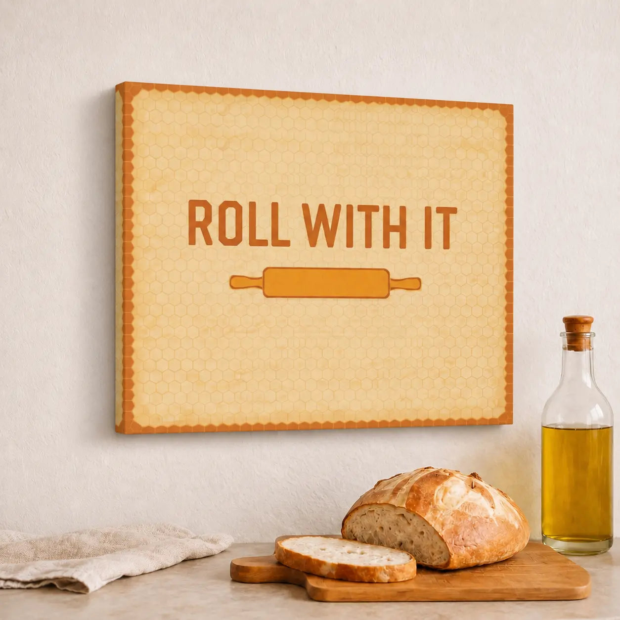 Canvas print with 'Roll with It' text and a rolling pin graphic, placed above a table with bread and oil.